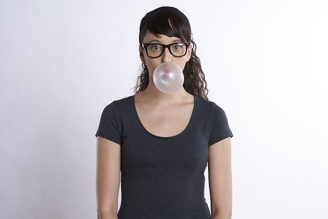 meitene ar brillēm burbuļgumija košļājamā gumija